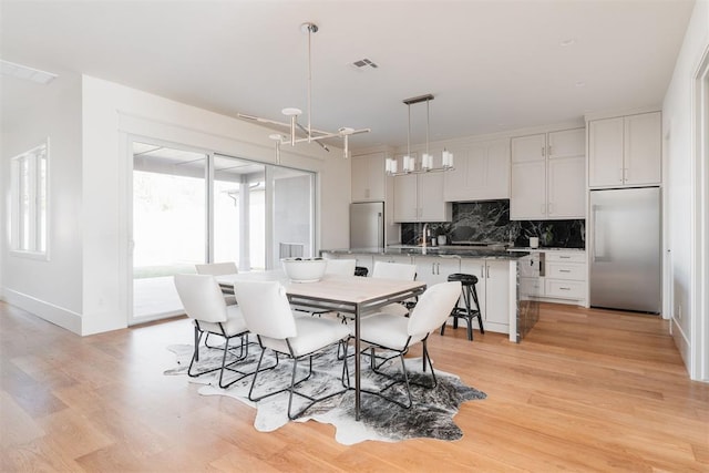 dining room featuring a notable chandelier and light hardwood / wood-style floors