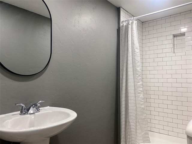 bathroom featuring a shower with shower curtain and sink