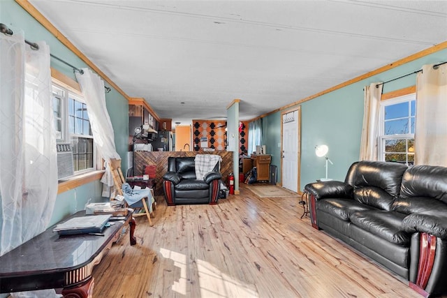 living room with light hardwood / wood-style flooring, plenty of natural light, and ornamental molding