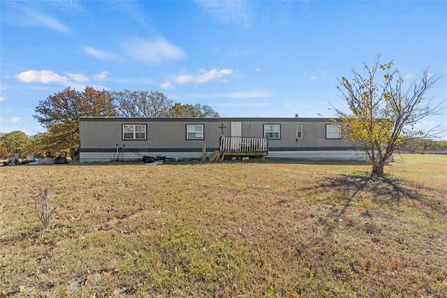 view of front facade featuring a wooden deck and a front yard