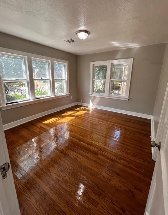 spare room featuring a textured ceiling and dark wood-type flooring