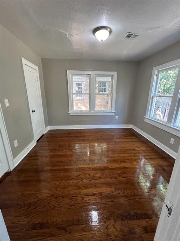 spare room with dark wood-type flooring and a textured ceiling