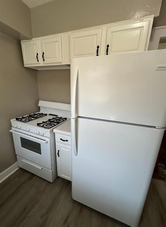 kitchen with white cabinets, white appliances, and dark hardwood / wood-style floors