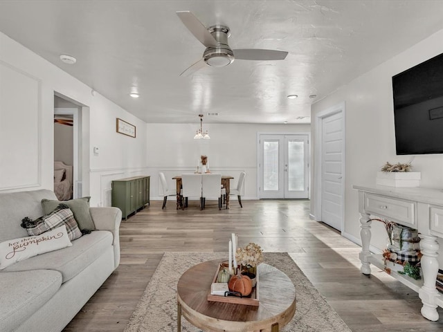 living room featuring french doors, light hardwood / wood-style flooring, and ceiling fan