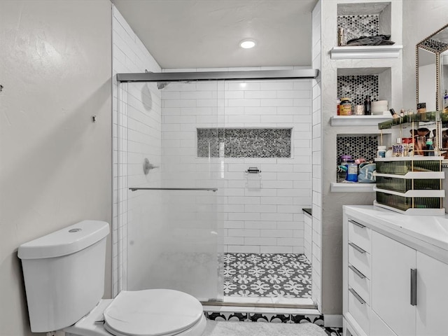 bathroom featuring vanity, toilet, and walk in shower