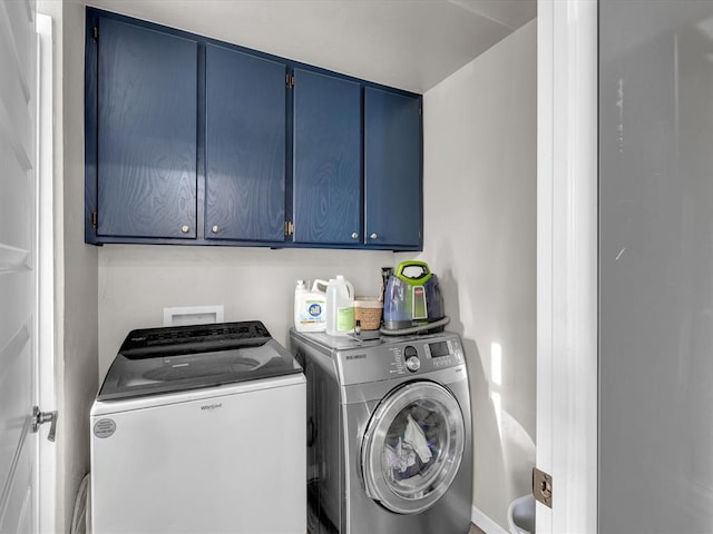 washroom featuring washer and dryer and cabinets