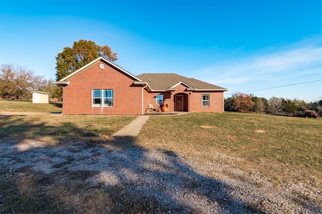 ranch-style home with a front yard and a storage unit