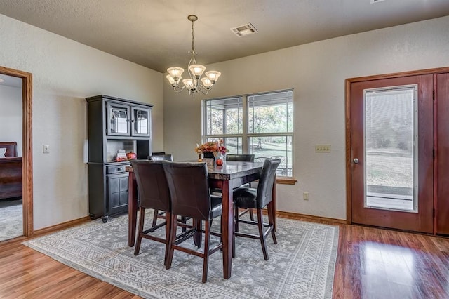 dining room featuring dark hardwood / wood-style floors and a notable chandelier