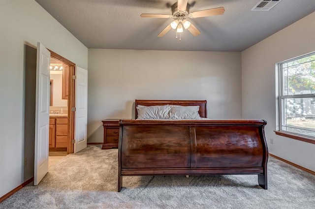 bedroom featuring connected bathroom, ceiling fan, and light colored carpet