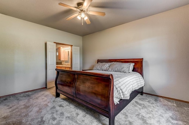 carpeted bedroom with ceiling fan and ensuite bath