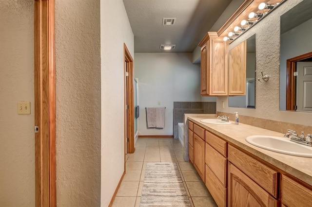 bathroom featuring tile patterned flooring, vanity, and a bathtub