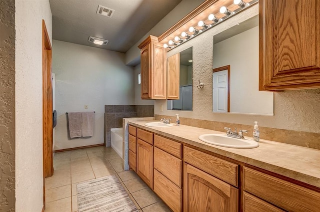 bathroom featuring tile patterned flooring, vanity, and a bathtub