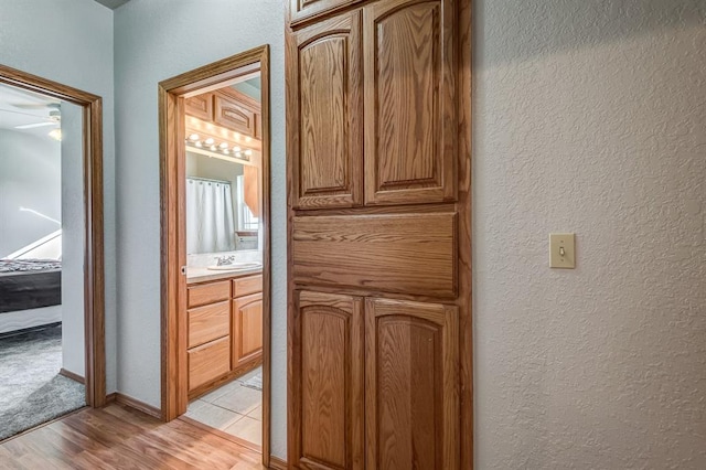 corridor featuring light hardwood / wood-style flooring and sink