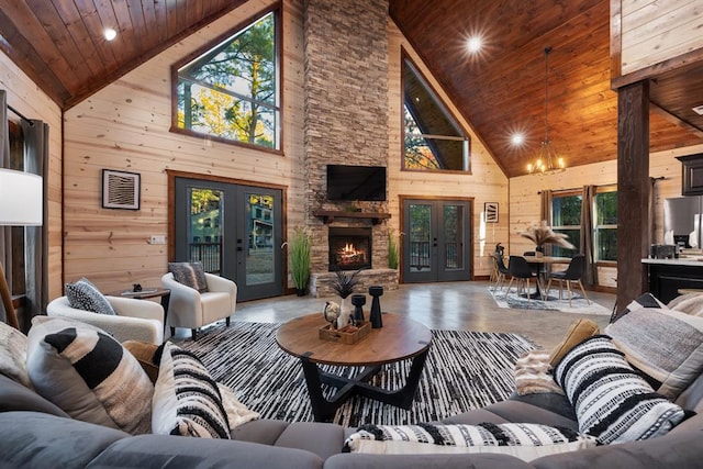 living room with a fireplace, wood ceiling, wooden walls, and french doors