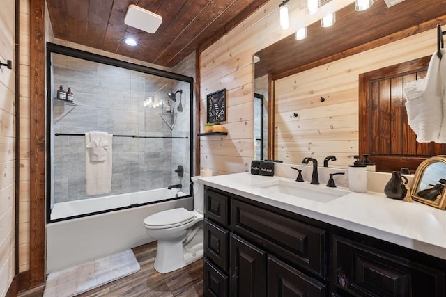 full bathroom with toilet, combined bath / shower with glass door, wood walls, wood ceiling, and vanity