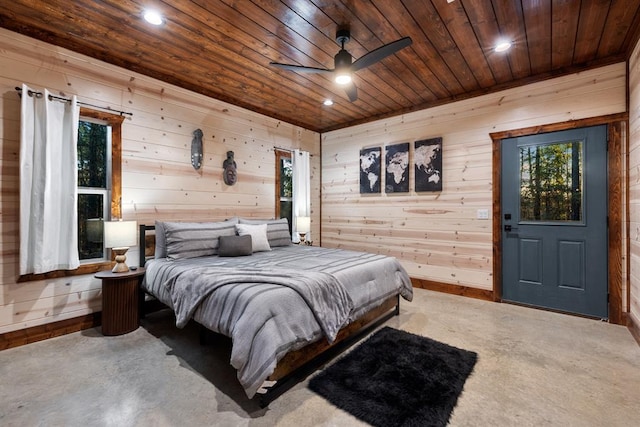 bedroom with wooden ceiling, ceiling fan, and wood walls