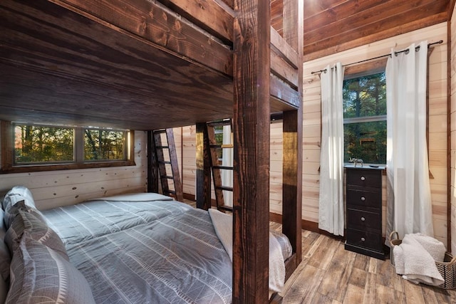 unfurnished bedroom featuring wooden ceiling, light wood-type flooring, and wood walls