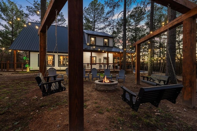 back house at dusk featuring an outdoor fire pit