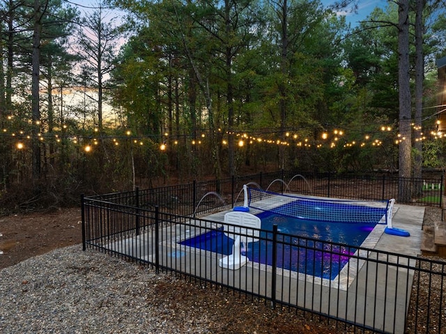 pool at dusk featuring a patio