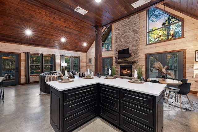 105 Triton Trl, Broken Bow, OK 74728 - kitchen with dark cabinets, open floor plan, wooden ceiling, finished concrete flooring, and wood walls