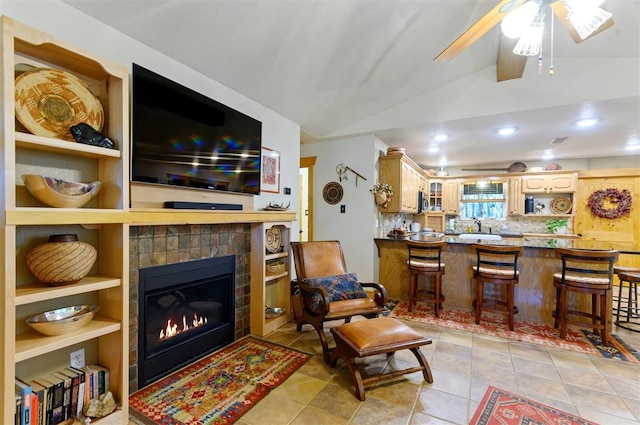 living room featuring a fireplace, ceiling fan, and lofted ceiling