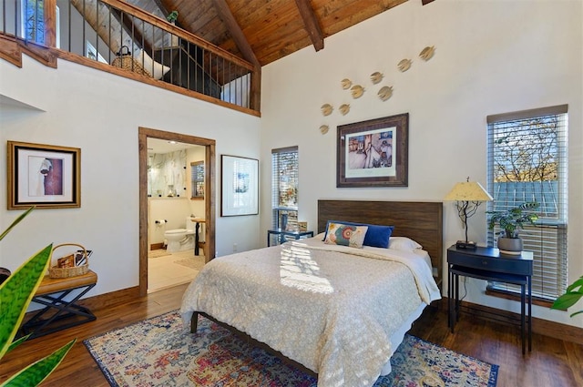 bedroom with dark hardwood / wood-style flooring, wooden ceiling, a high ceiling, and connected bathroom