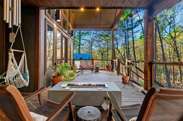 wooden balcony with an outdoor fire pit and a wooden deck