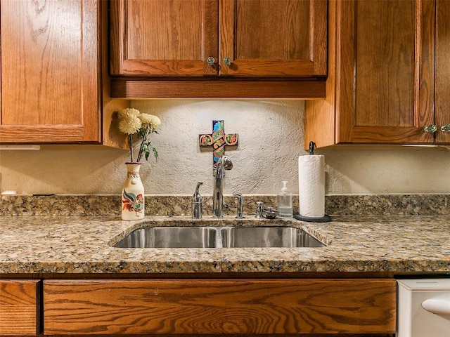 kitchen featuring sink and light stone counters