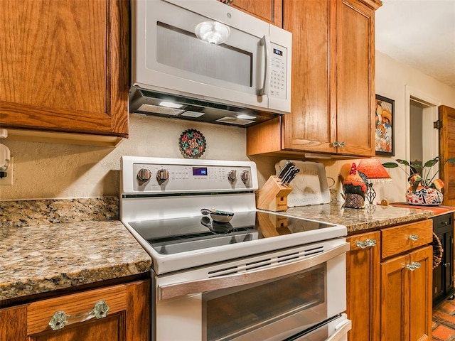 kitchen with light stone counters and white appliances