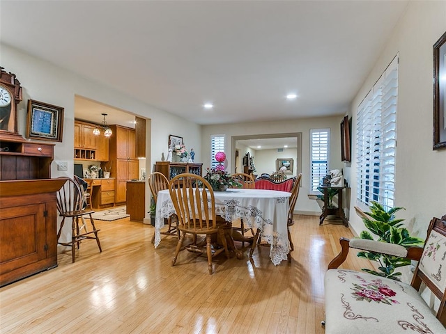 dining room featuring light wood-type flooring and a chandelier