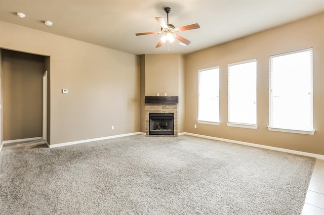 unfurnished living room featuring ceiling fan, light colored carpet, and a tiled fireplace