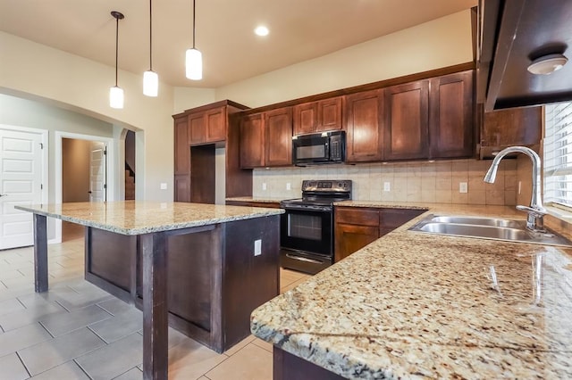 kitchen featuring light stone countertops, sink, tasteful backsplash, decorative light fixtures, and black appliances