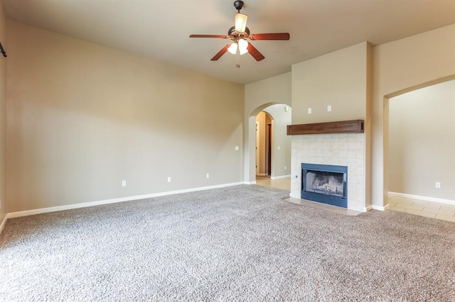 unfurnished living room with ceiling fan, light colored carpet, and a fireplace