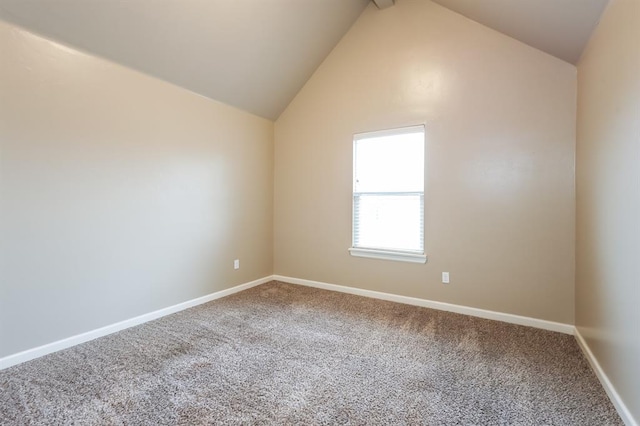 unfurnished room featuring carpet and vaulted ceiling with beams