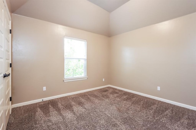 empty room featuring carpet and vaulted ceiling