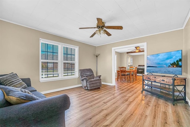 living room with light wood-type flooring, ceiling fan, and ornamental molding