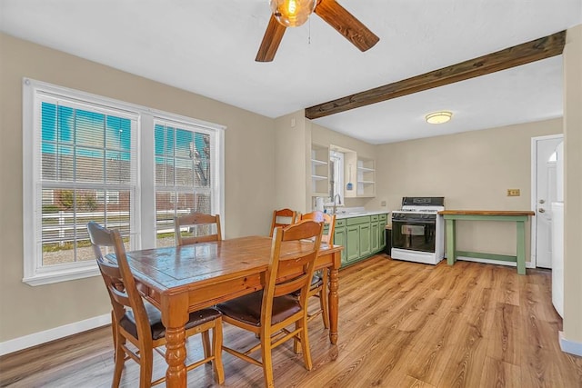 dining area featuring ceiling fan, sink, and light wood-type flooring