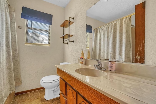 bathroom featuring vanity, toilet, and a textured ceiling