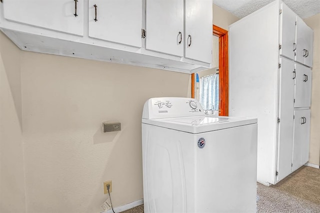 clothes washing area featuring light colored carpet, cabinets, a textured ceiling, and washer / dryer