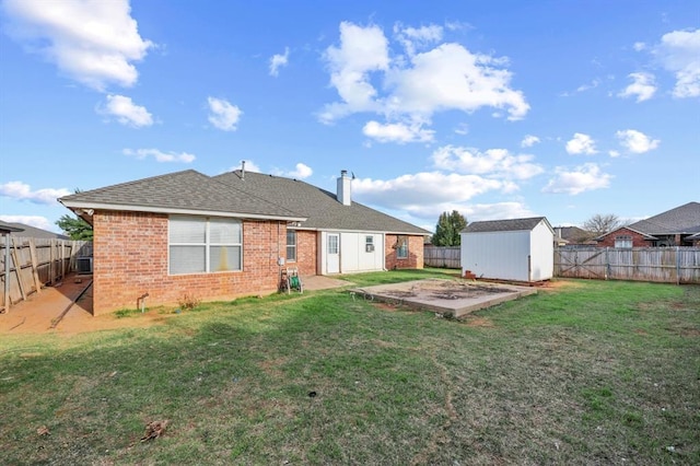 rear view of property featuring a lawn, a patio, and a storage unit