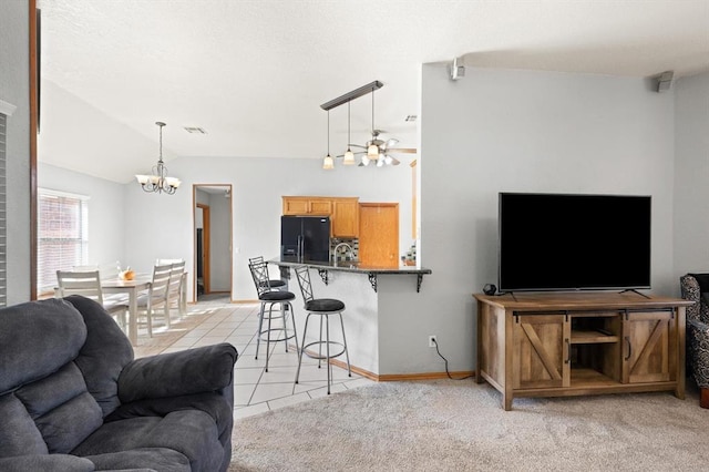 tiled living room with lofted ceiling and ceiling fan with notable chandelier