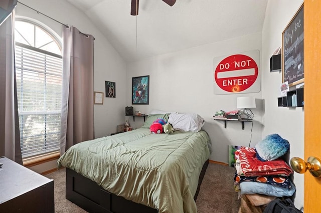 bedroom with vaulted ceiling, ceiling fan, carpet floors, and multiple windows