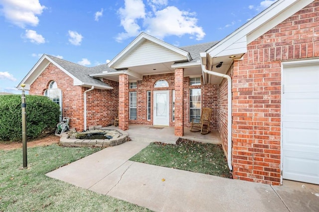 doorway to property featuring a garage and a yard