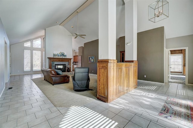 tiled living room featuring beamed ceiling, ceiling fan with notable chandelier, and high vaulted ceiling