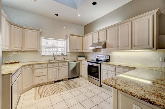 kitchen featuring appliances with stainless steel finishes, sink, light stone counters, and light tile patterned flooring