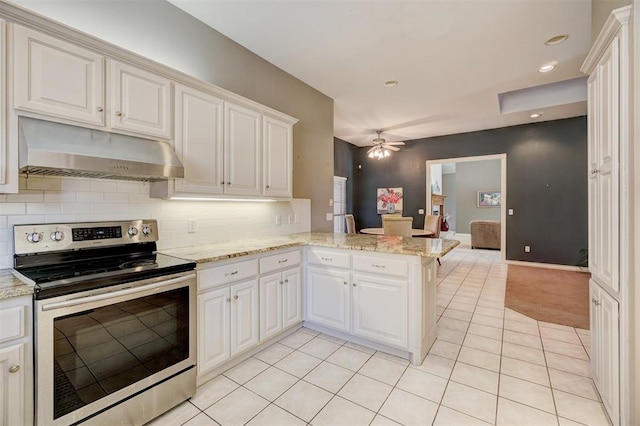 kitchen with kitchen peninsula, light stone countertops, light tile patterned floors, white cabinetry, and stainless steel range with electric cooktop