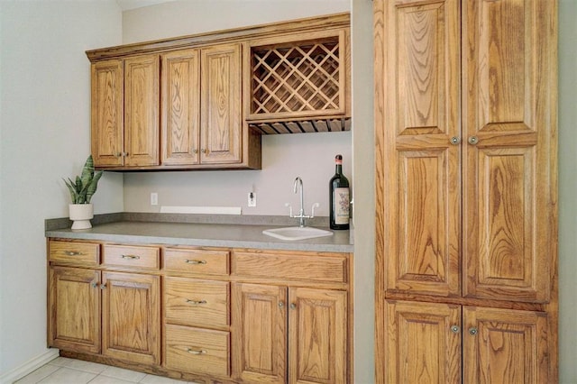 bar featuring light tile patterned floors and sink