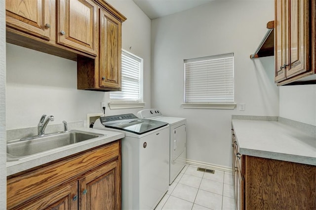 clothes washing area featuring cabinets, separate washer and dryer, light tile patterned flooring, and sink