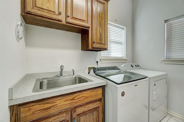 laundry room featuring cabinets, washing machine and dryer, and sink