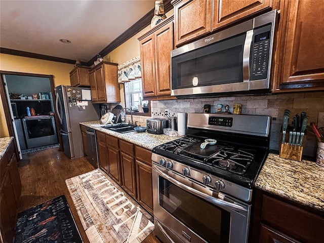 kitchen with dark hardwood / wood-style flooring, sink, light stone counters, and stainless steel appliances